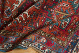 Vintage Karaja rug detail with hook-enveloped geometric designs in brick red, mallard green, and blue.