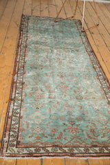 Distressed Malayer rug runner's fringe and pale wine red serpent motif border.