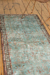 Distressed Persian Malayer runner's textured pile, featuring faded powder blue and pale wine Herati motifs.