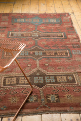 Worn texture and geometric patterns on a vintage Kazak rug corner with polychromatic selvage.