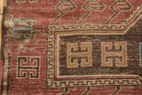 Worn charcoal brown geometric motif detail on a dusty cochineal red vintage Kazak rug.