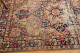 Large threadbare stripe with tattered interior on antique Kerman rug, revealing ivory.