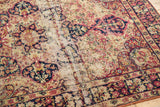 Threadbare stripe and hard tatter on antique Kerman rug, with faded red and navy floral patterns.