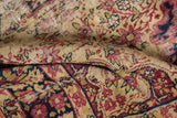 Detailed view of antique Kerman rug's aged pile, revealing foundation and red floral motifs.