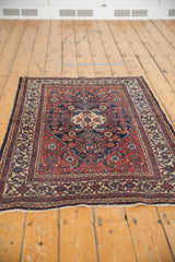 Close-up of the vintage Bibikabad rug's navy and ivory borders and madder red Herati field.