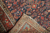 Vintage Dargezine rug corner revealing navy Herati motifs, light foundation, and tattered edge.