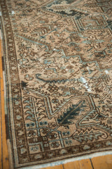 Distressed vintage Heriz carpet's polychromatic side selvage, geometric pattern, and visible wear.