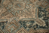 Distressed vintage Heriz carpet texture with geometric beige, blue, and brown patterns.
