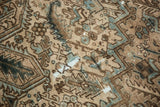 Distressed vintage Heriz rug pile showing exposed knot heads, beige, brown, and blue patterns.
