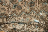 Distressed pile texture of a vintage Heriz rug, with beige, brown, and blue geometric patterns.