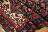 Detailed Herati motif and meandering vine border in rich madder root red, navy, and ivory.