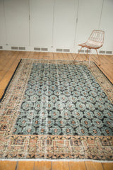 Distressed Oushak rug with geometric terra cotta border and faded floral field.