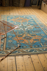 Distressed vintage Akstafa design Oushak rug detail with blue and tangerine animal motifs.