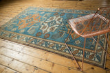 Distressed Oushak carpet corner with a sky blue and tangerine serrated leaf border.