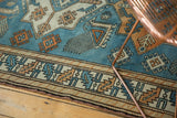 Distressed vintage Oushak rug border, with sky blue, tangerine, and ivory Kazak style geometric motifs.