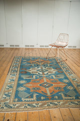 Akstafa-style geometric pattern, blue and tangerine colors, and low distressed pile.