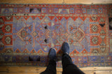Distressed Oushak runner, pale purple, madder red geometric patterns, even wear underfoot.