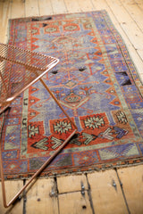 Distressed vintage Oushak rug, intricate geometric patterns in faded madder red and dusty purple.