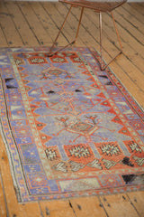 Distressed Oushak runner's border and field, with geometric patterns in dusty purple and madder red.