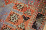 Geometric patterns and soft pile wear in red, dusty purple, charcoal black.