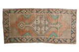 Distressed vintage Oushak runner features an apricot field with geometric diamond medallion.