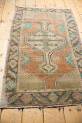 Decorative geometric spandrel motifs on a vintage distressed Oushak rug in dusty apricot and mint.