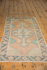 Distressed fringe and patterned end border of the vintage Oushak rug, showing wear and apricot tones.