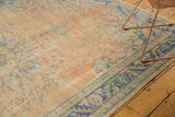 Distressed vintage Oushak rug with faded peach field and worn blue and green border.