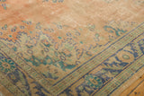 Distressed vintage Oushak rug close-up: faded rose field, dusty blue, ocean green border.