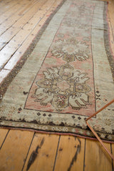 Distressed Oushak runner's chocolate brown meandering vine border and worn dusty rose pile.