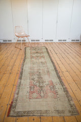 Distressed Oushak runner corner, showcasing muted dusty rose, silver, and bronze tones with even wear.