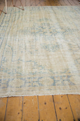 Decorative distressed texture of vintage Oushak carpet with antique ivory and pale blue tones.