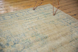 Faded pale blue floral pattern on distressed vintage Oushak rug with visible foundation.