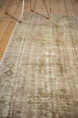 Distressed vintage Oushak runner showing textured pile, pale lilac, ivory, and brown geometric motifs.