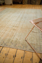 Distressed vintage Oushak carpet, showcasing its muted ivory and beige textured pile.