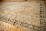 Worn coffee chocolate lotus palmette border detail on a distressed Oushak rug's pale peach field.