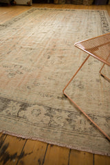 Close-up of distressed fringe and traditional Oushak rug pattern in pale peach and ivory.
