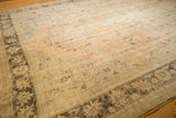 Distressed Oushak rug corner, coffee chocolate palmette border, pale peach field.