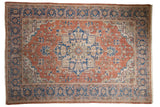 Vintage distressed Oushak rug, dusty red field with central blue medallion and floral designs.
