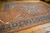 Distressed Oushak rug field with rust blush, blue vinery, serrated leaves, and soft wear.