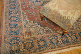 Distressed vintage Oushak corner, showing sky blue, rust, and ivory floral borders.