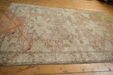 Distressed vintage Oushak rug, showing pale blush rose and ivory motifs with faint foundation.
