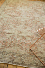 Distressed texture of the vintage Oushak rug with blush rose and antique ivory tones.