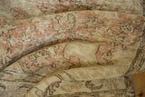 Texture of the distressed Oushak carpet showing pale blush rose and antique ivory tones.