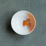 Handmade ceramic ring dish in Desert with a glossy white and sandy orange interior.