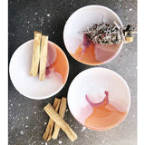 Three handmade ceramic bowls in Desert glaze, styled with palo santo and a sage smudge stick.