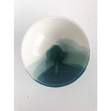 Round ceramic bowl with a glossy white interior and layered ocean-blue watercolor glaze.