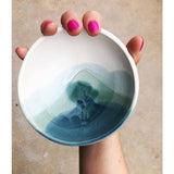 Handmade Ocean ceramic bowl with a layered blue-green glaze held to show its size.