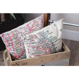Two throw pillows with vintage map print showing city names inside a wooden crate.
