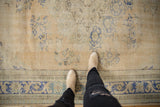 Distressed vintage Oushak rug with dusty royal blue border and worn, textured pile underfoot.